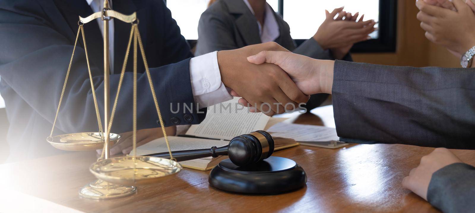 Businessman shaking hands to seal a deal with his partner lawyers or attorneys discussing a contract agreement. by wichayada