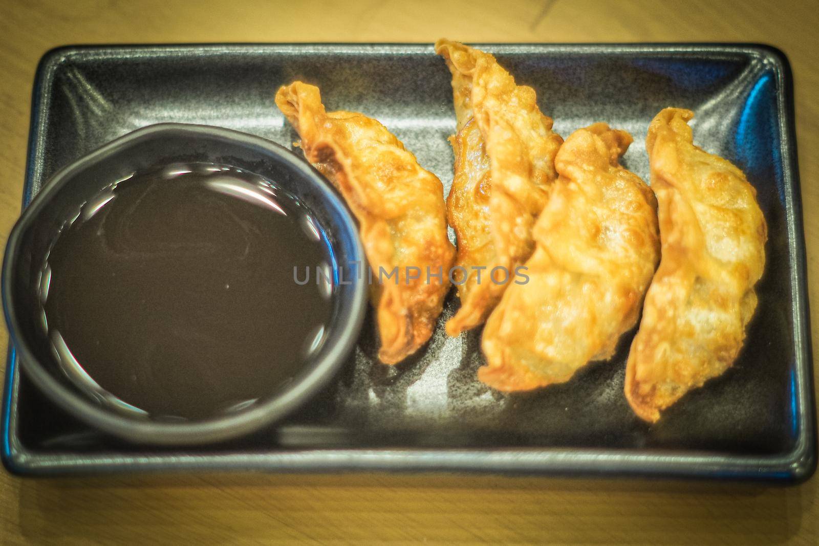 Chinese Pan-Fried Dumplings in ceramic rectangular shape black color plate. Chinese traditional food business still life