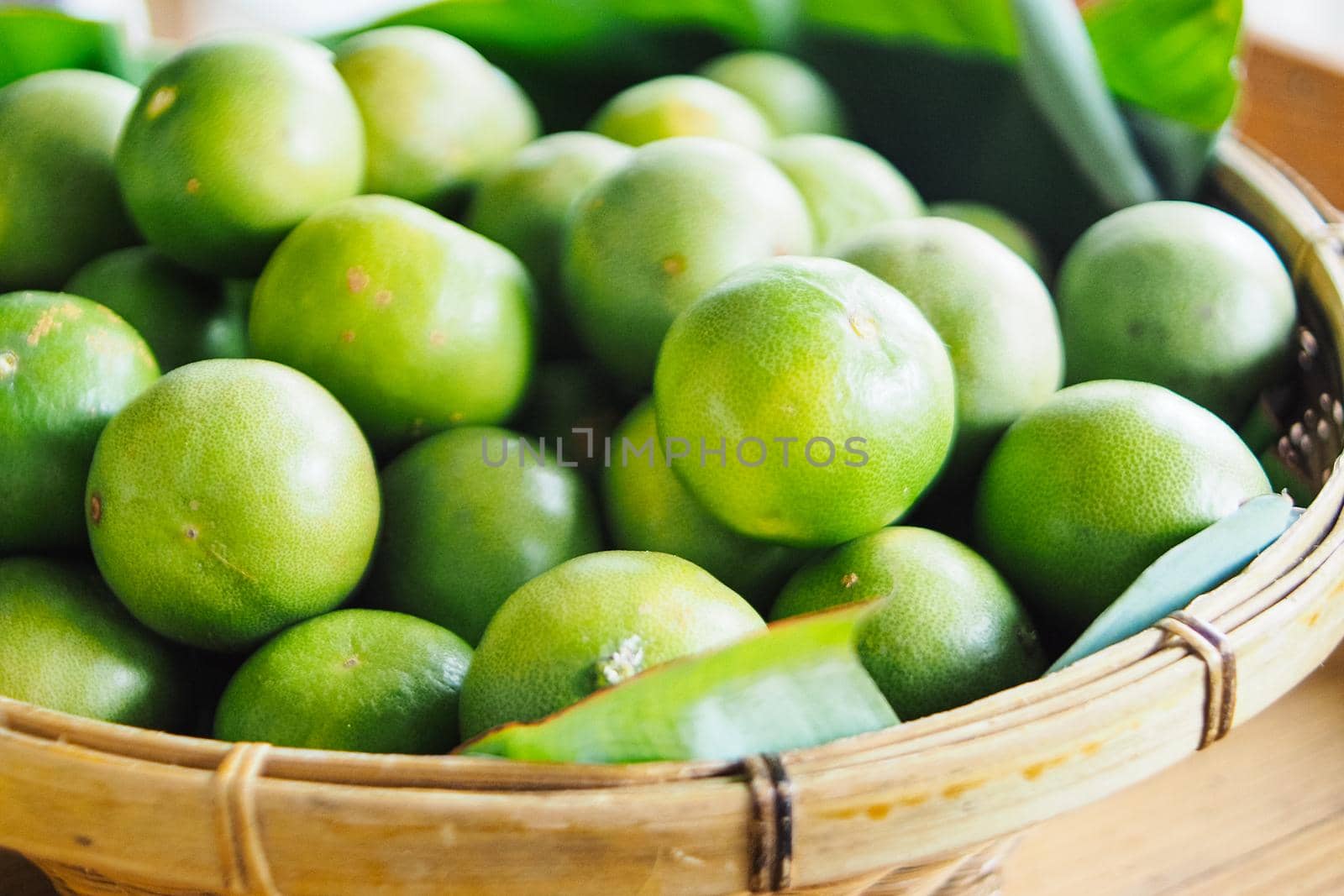 Limes in woven basket at a farmers market industry agriculture.