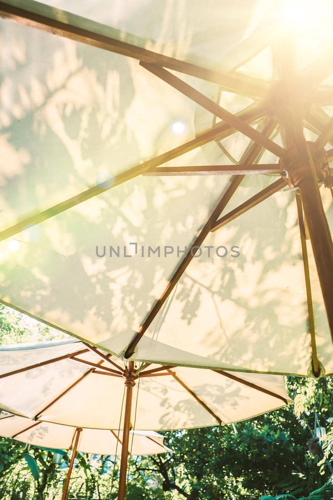 Sunlight through white parasol umbellar. Garden furniture function design decoration.