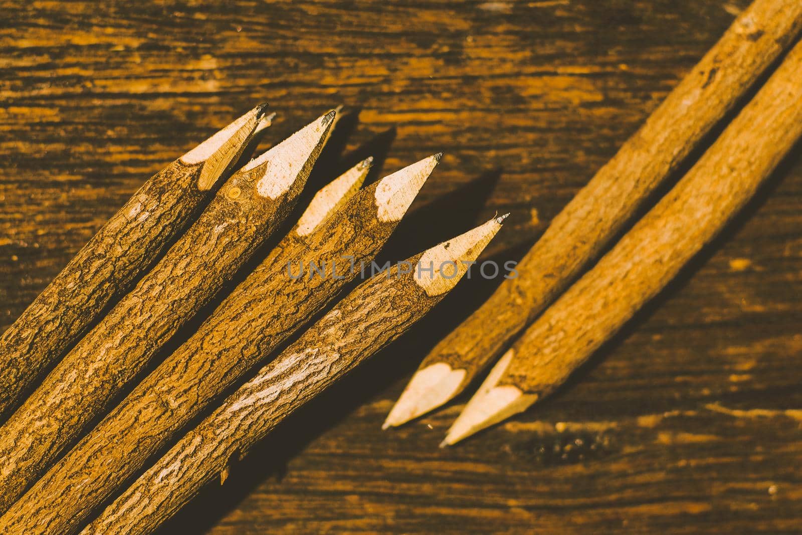 Sharp nature wood pencils on old wooden table in background by Petrichor