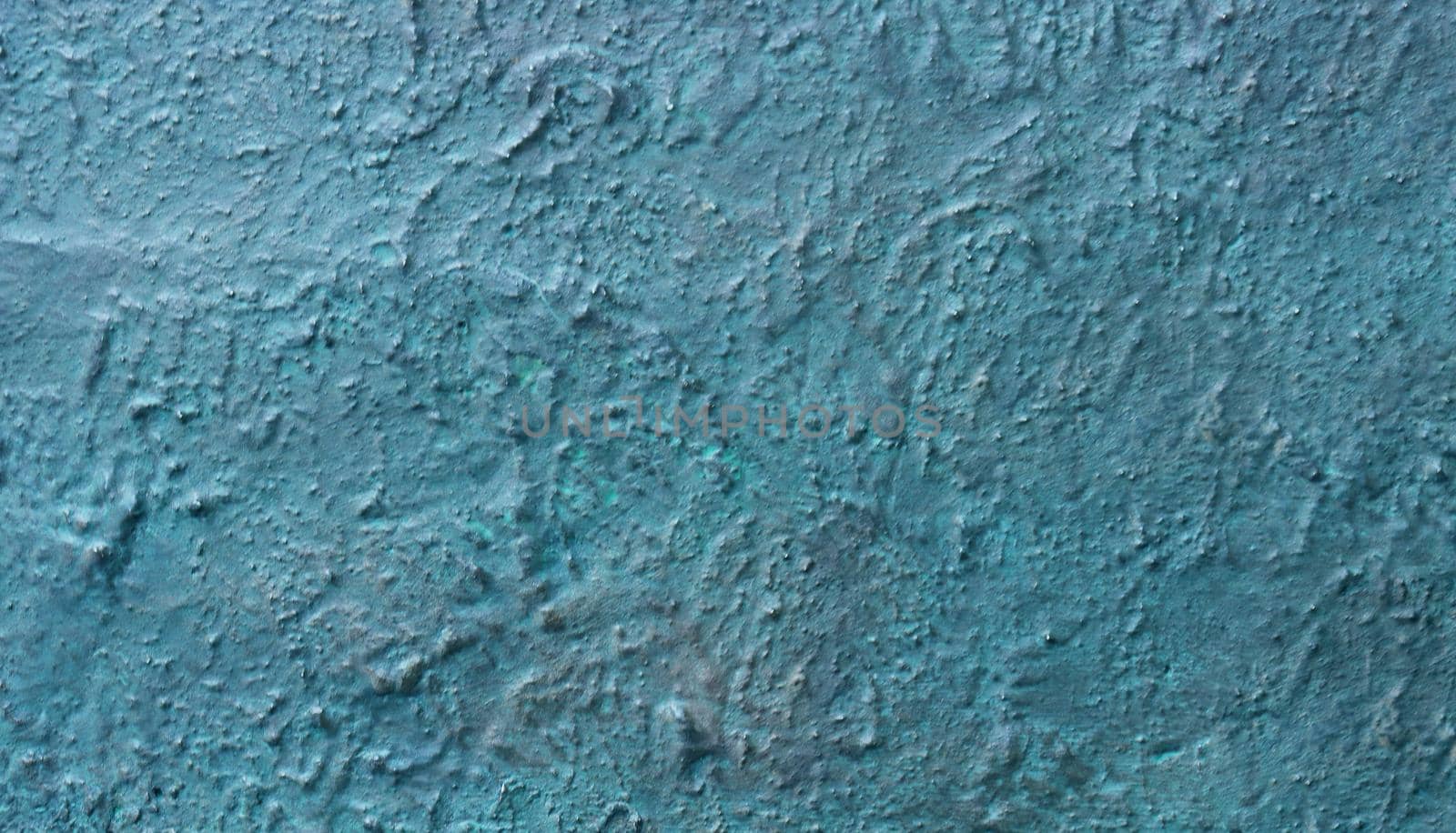 Unevenly plastered and painted blue wall.