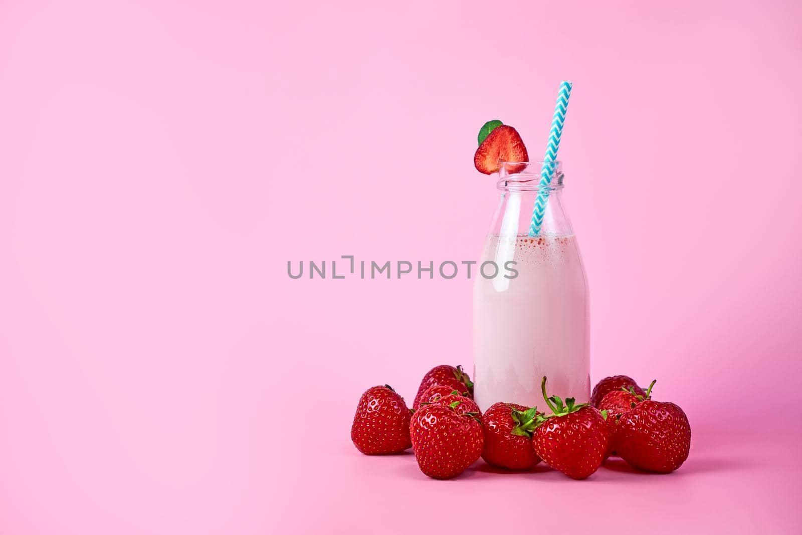 Strawberry smoothie or milkshake in glass jar with berries on pink background. Healthy summer drink by Svetlana_Belozerova