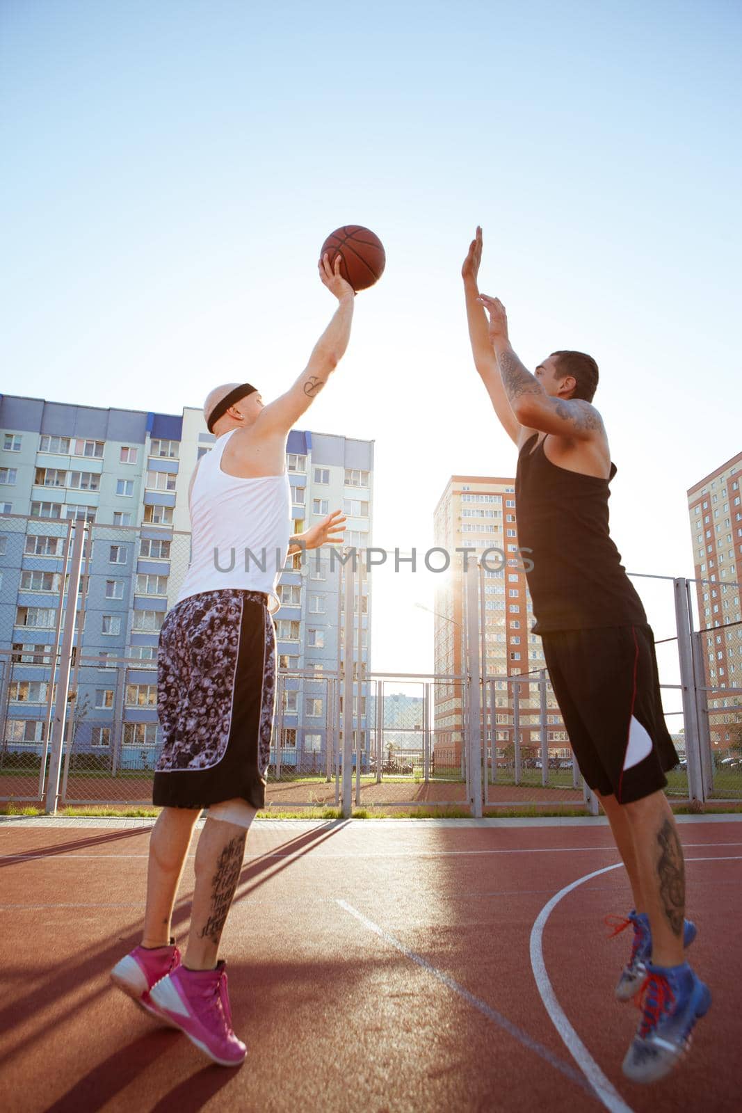 Two guys jump stretch to the ball on the basketball court by studiodav
