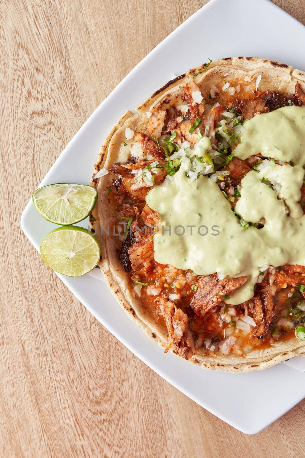 variety of delicious typical mexican food and ingredients such as salsas, red, green, guacamole, lemon, tomato and onion.