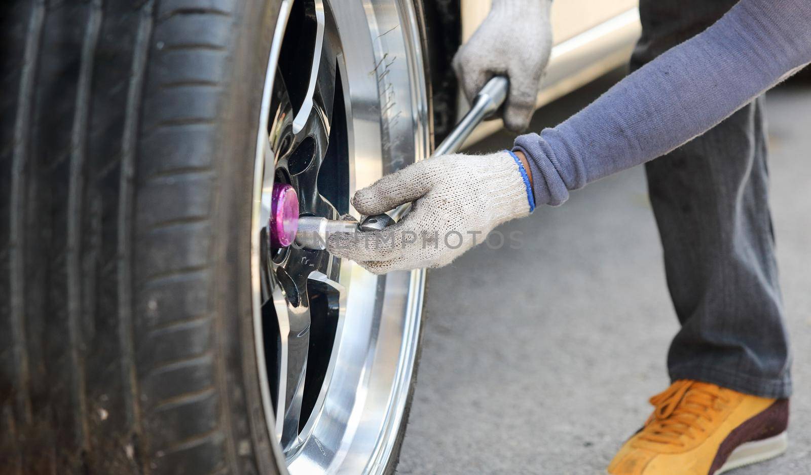 Auto mechanic changing racing car wheel