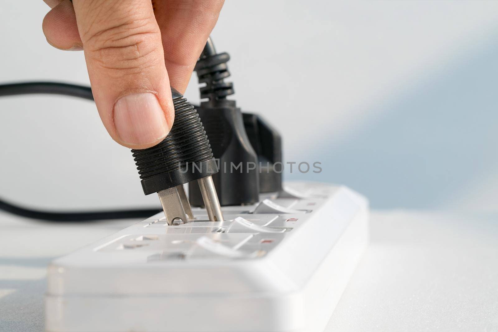 Close up Elderly hand plugging into electrical outlet by toa55