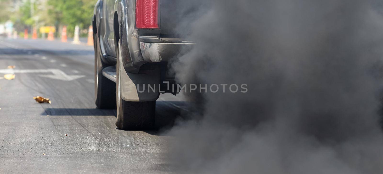 Air pollution from vehicle exhaust pipe on road.