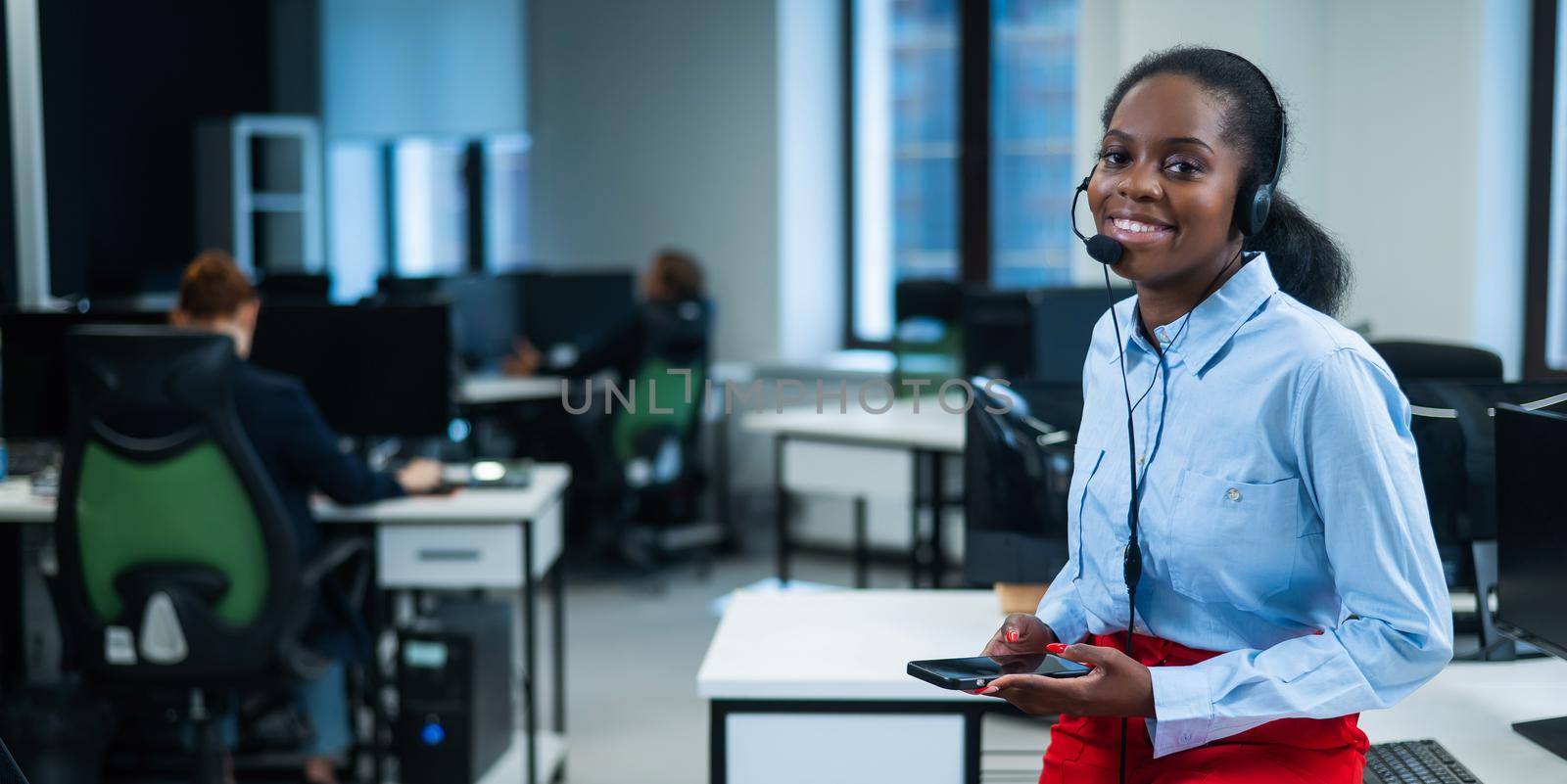 African female call center employee using smartphone. by mrwed54