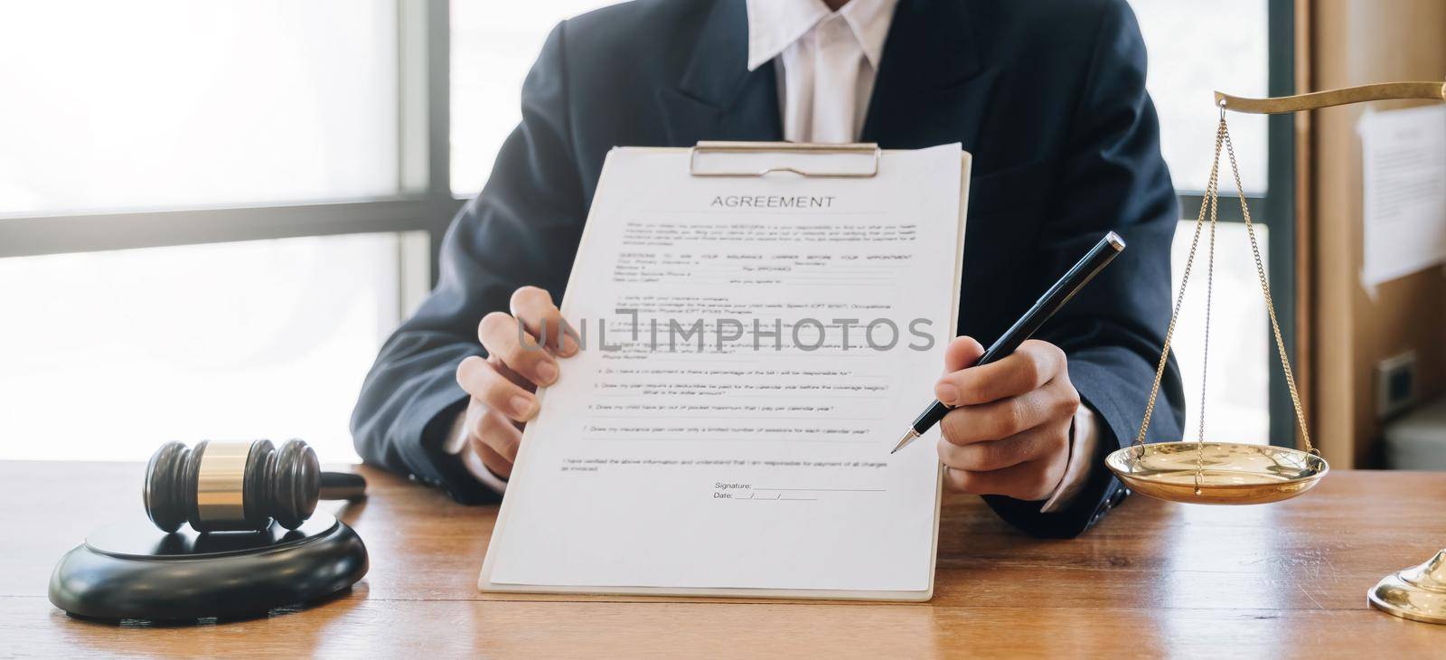 Male lawyer working with contract papers and wooden gavel on tabel in courtroom. justice and law ,attorney, court judge, concept. by wichayada