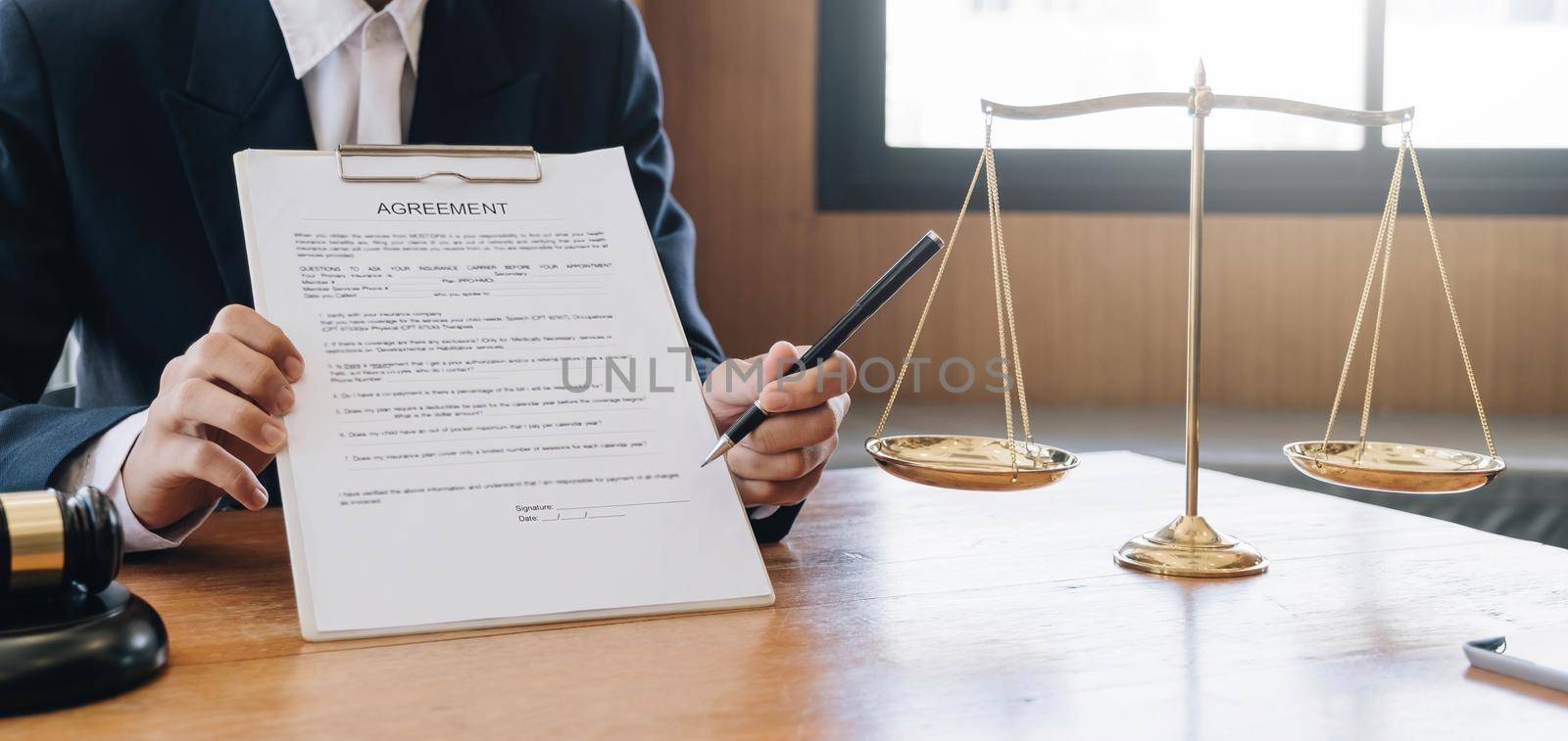 Male lawyer working with contract papers and wooden gavel on tabel in courtroom. justice and law ,attorney, court judge, concept..