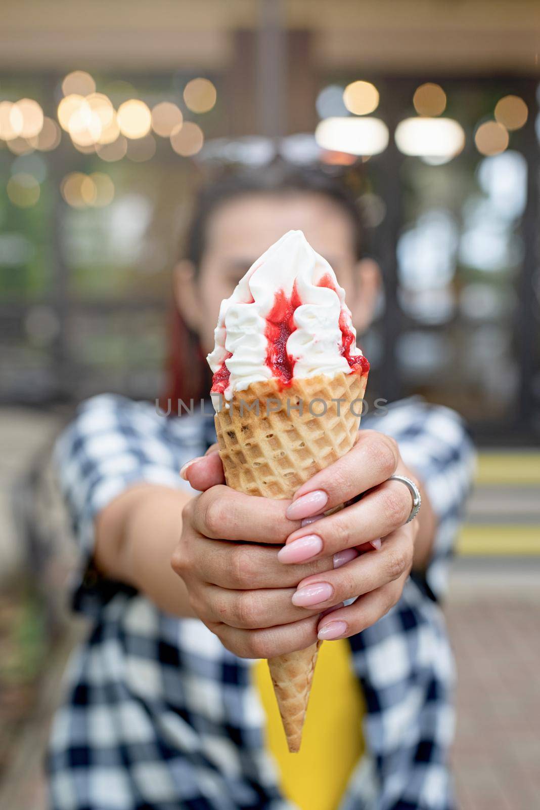 cheerful trendy woman with red hair eating ice cream at street by Desperada