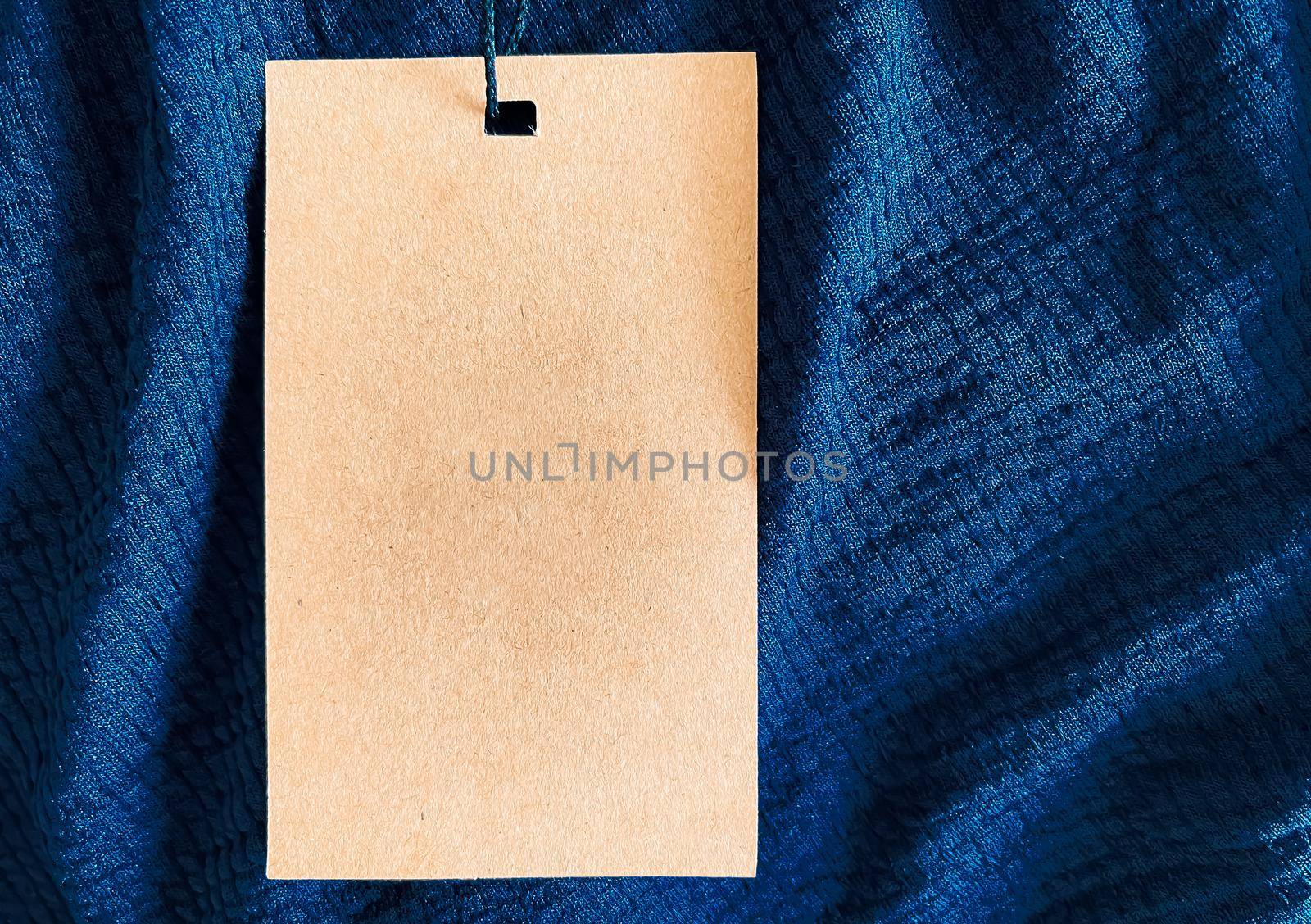 Blank fashion label tag, sale price card on luxury fabric background, shopping and retail concept