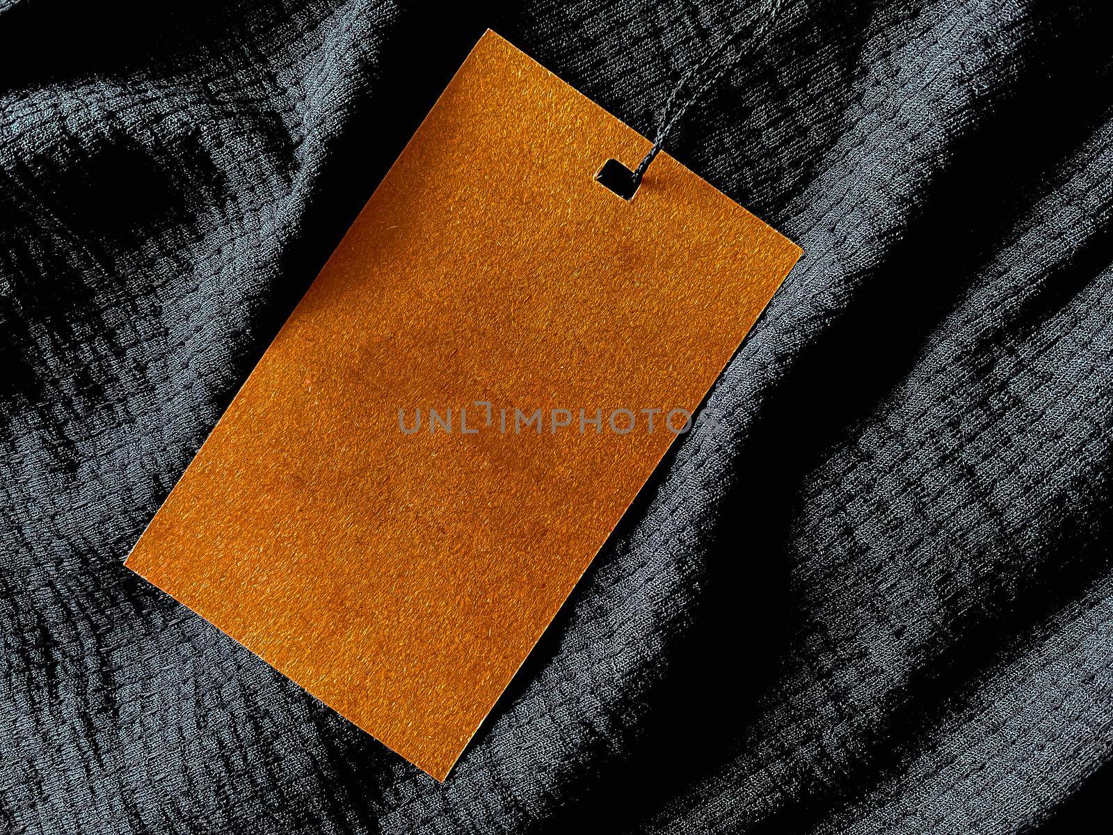 Blank fashion label tag, sale price card on luxury fabric background, shopping and retail concept