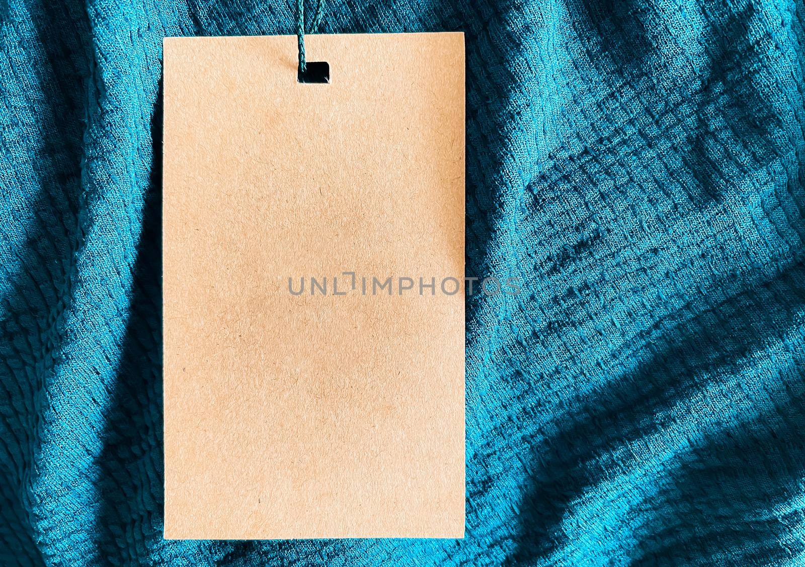 Blank fashion label tag, sale price card on luxury fabric background, shopping and retail concept