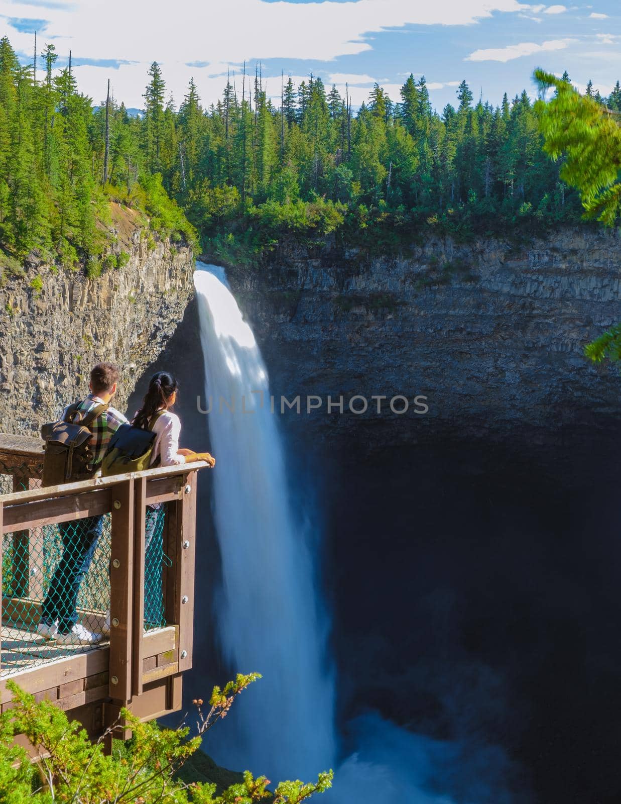 Helmcken Falls Wells Gray park British Colombia Canada, couple watching waterfall. a couple of men and women on a road trip in British Colombia in Canada standing by a waterfall in Wells Gray park BC