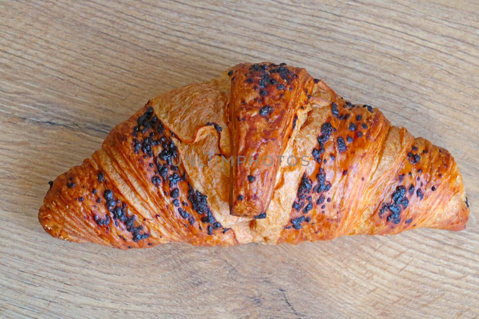 Croissant on a wooden background. Fresh and tasty pastries. Croissant for coffee or tea for breakfast