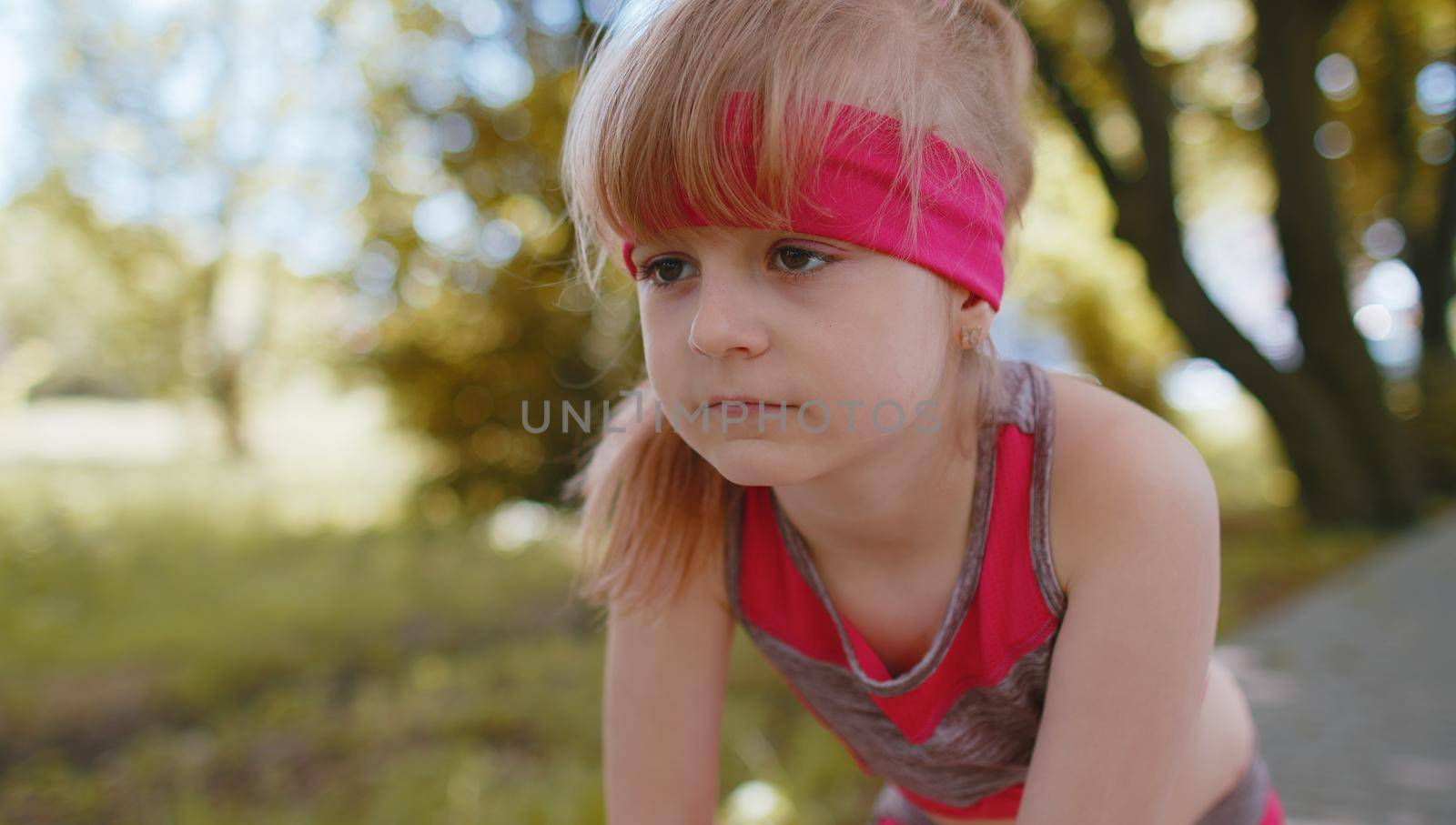 Athletic fitness sport motivated runner child girl training, preparing to run race marathon. Workout cardio in morning park. Toddler kid jogger enjoying healthy lifestyle. Active children motivation