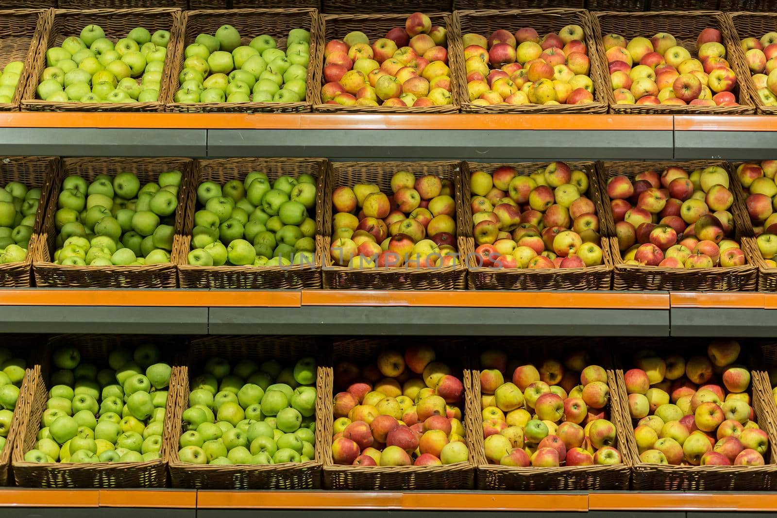 Shelves boxes with fruit colorful apples in the supermarket store on the counter