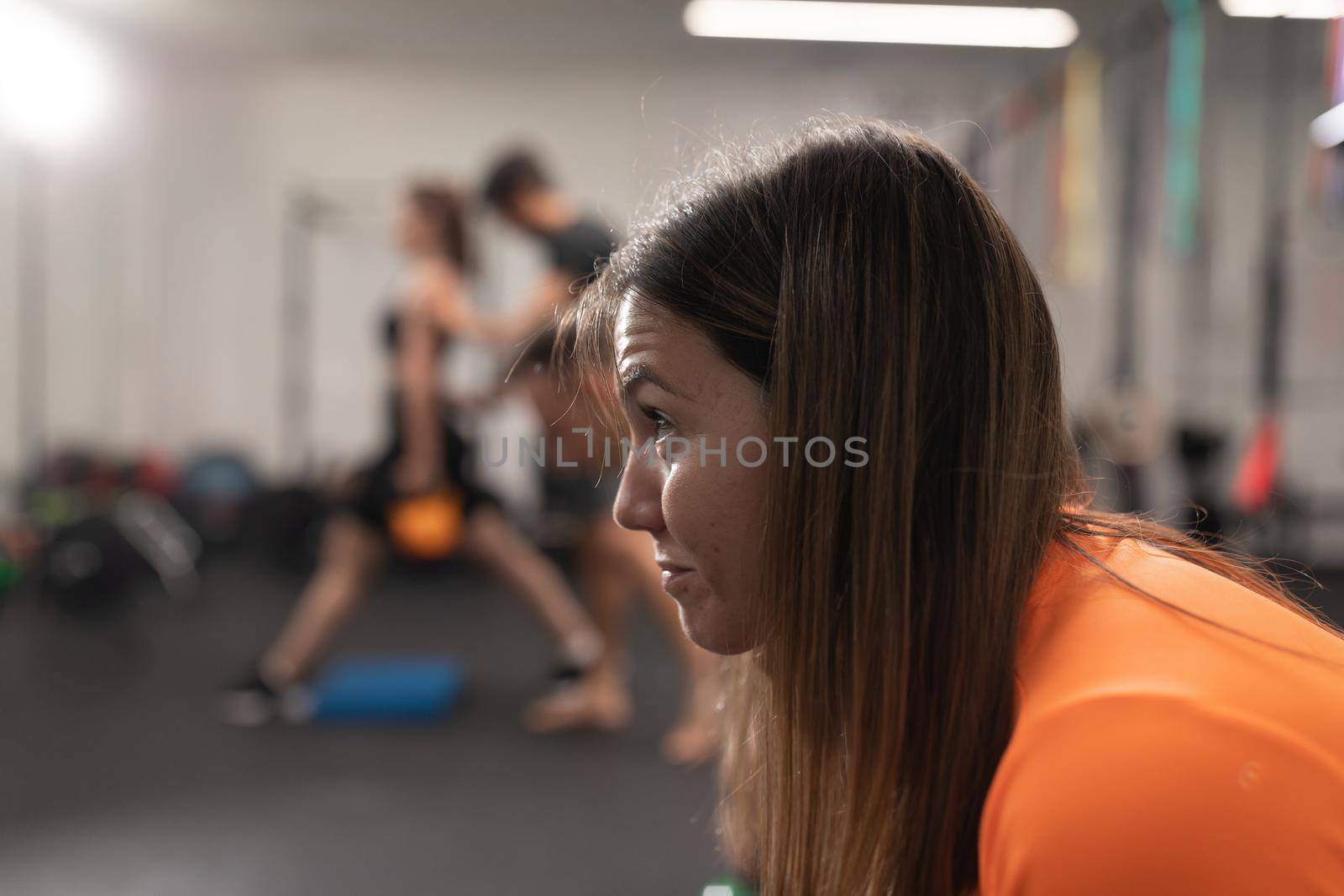 Candid portrait of a female trainee resting during a work out session at the gym