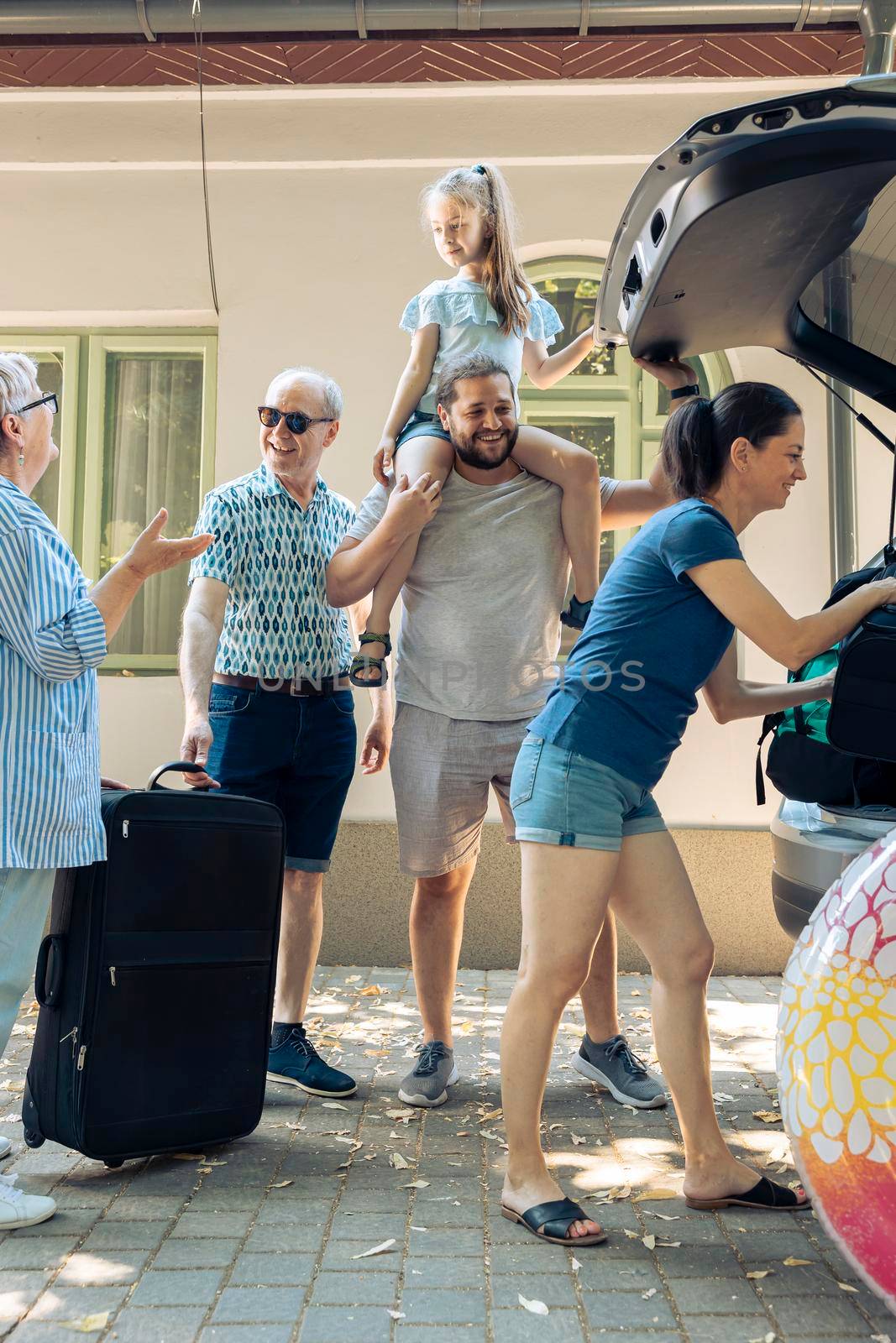 Big family loading luggage in trunk vehicle, preparing to leave on seaside vacation journey. Little child with parents and grandparents travelling with automobile to go on summer holiday.