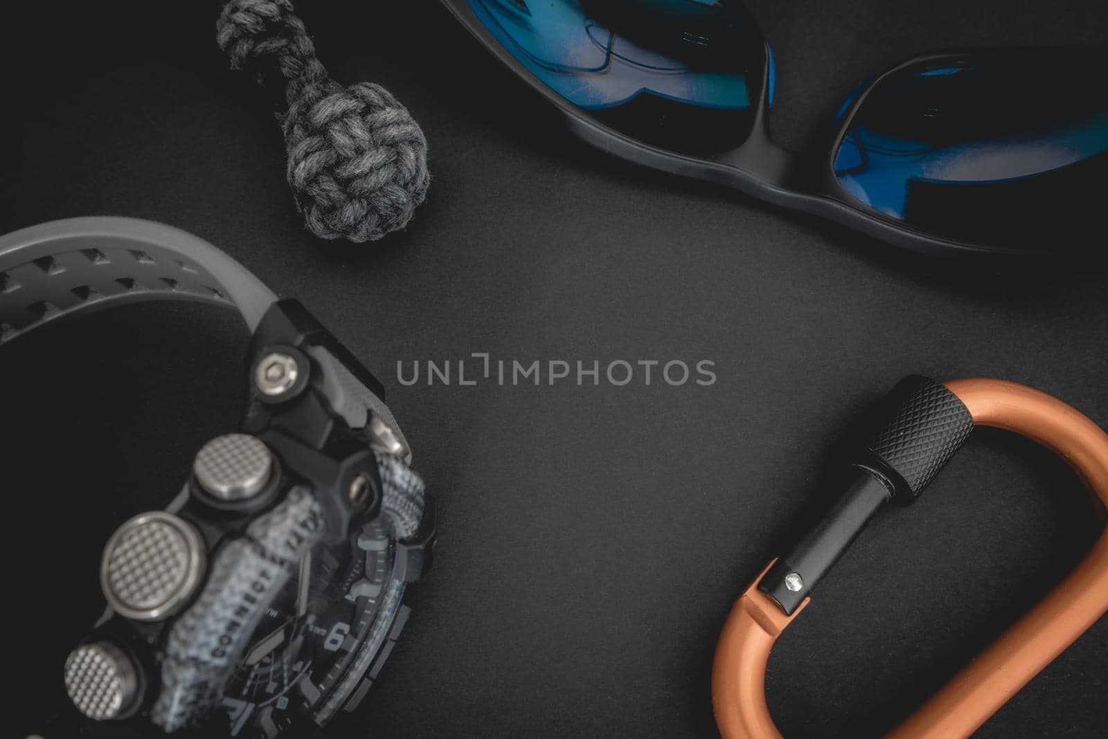 Flatlay from a bunch of Outdoor equipment,  on a dark background.