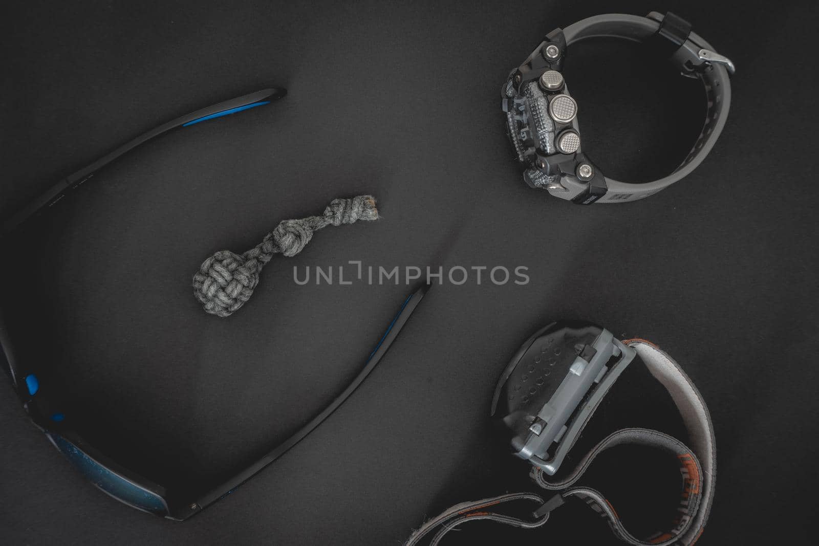 Flatlay from a bunch of Outdoor equipment,  on a dark background.