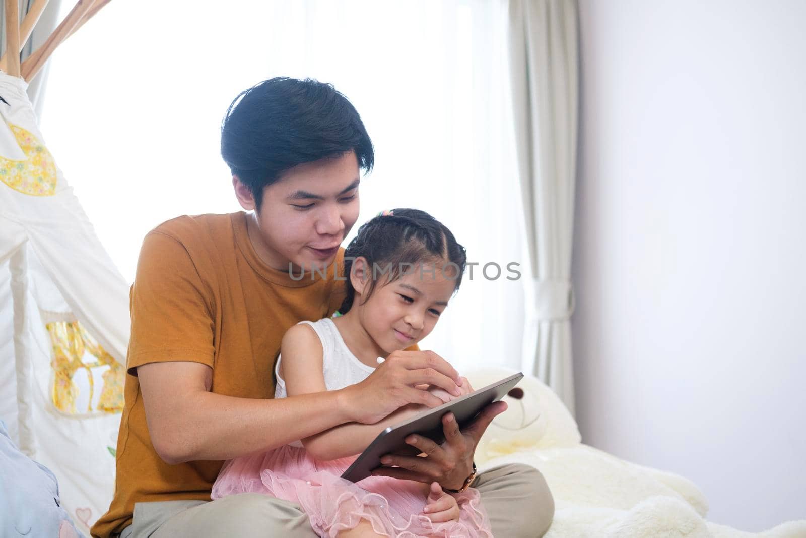 Asian father is helping and support parents teaching homework. by ijeab