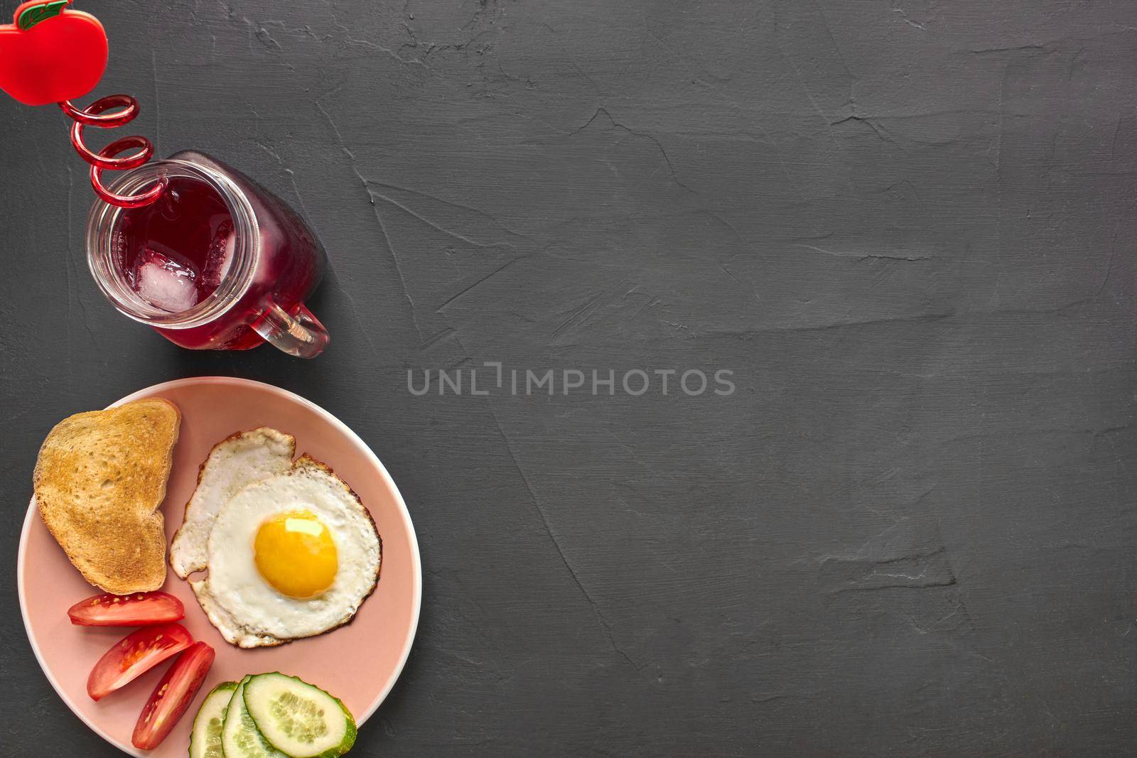 Top view of healthy and delicious breakfast on a black background with copy space. Fresh vegetables, scrambled eggs, toast, beverage for tasty and nutritious meal.