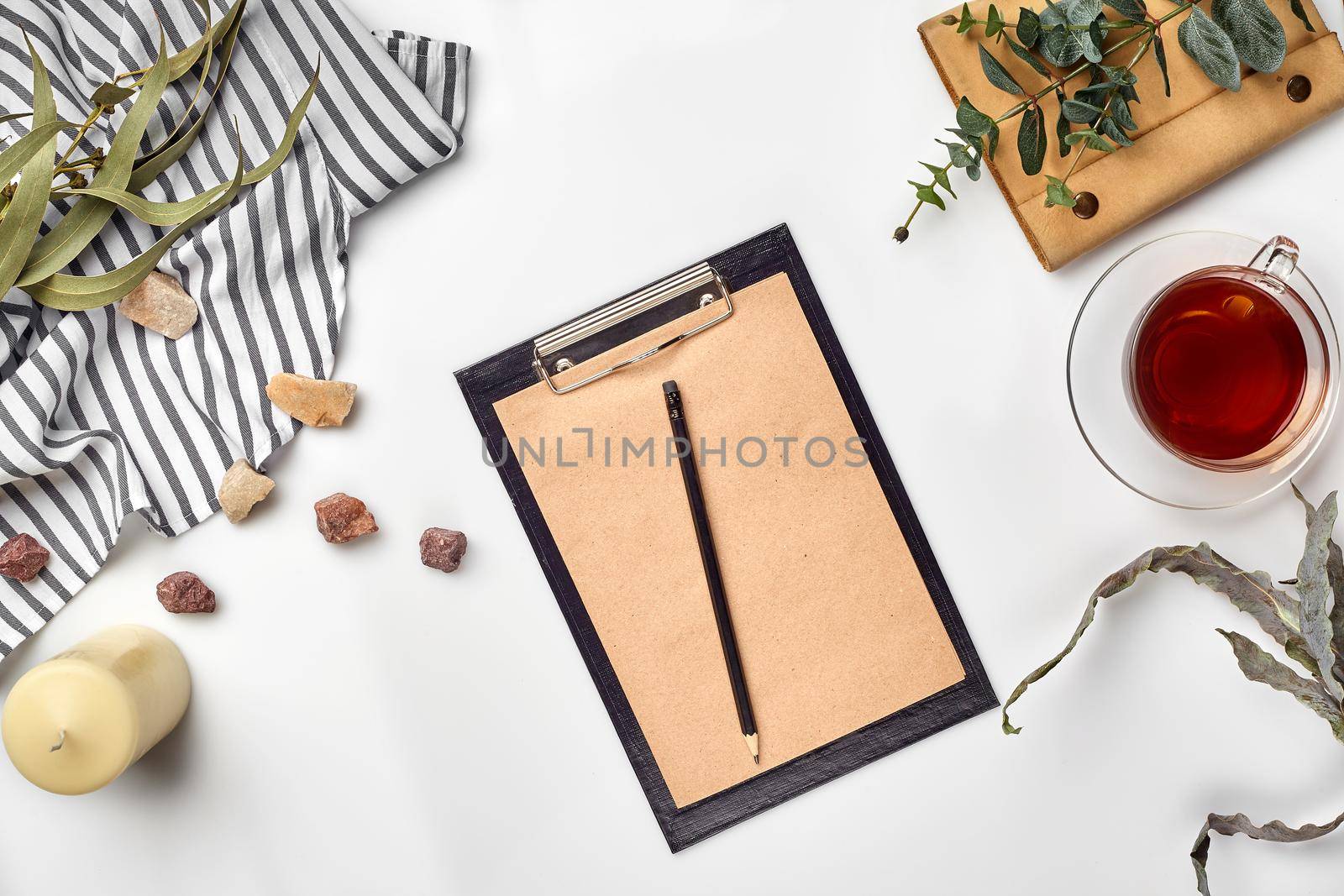 Blank opened notebook with cup of tea on white table. Top view. Writing concept by nazarovsergey