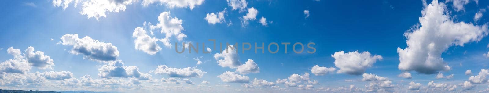 Panoramic view of blue sky with fluffy clouds by EdVal