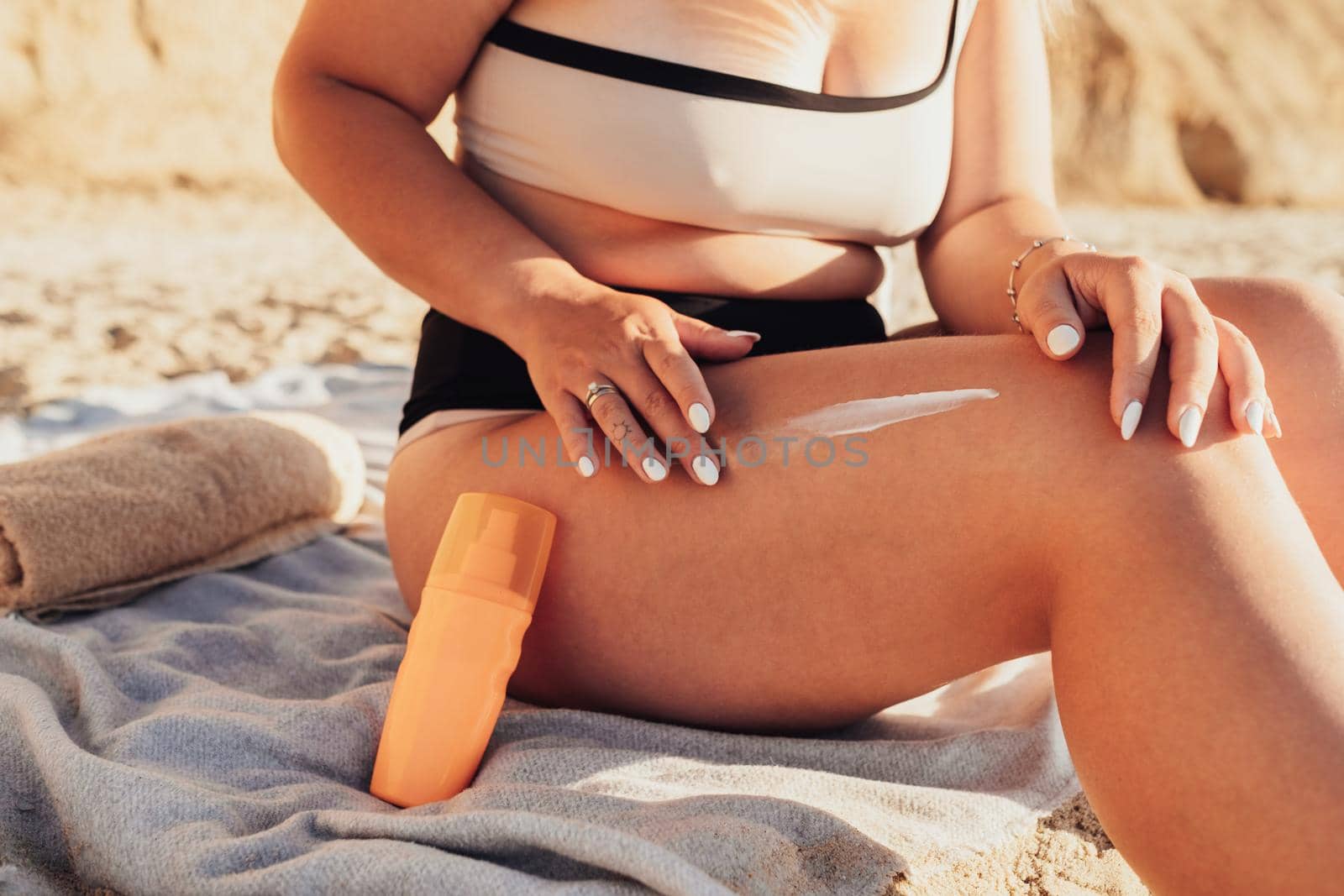 Close Up Young Woman Applying Sunscreen Cream on Her Leg on Beach