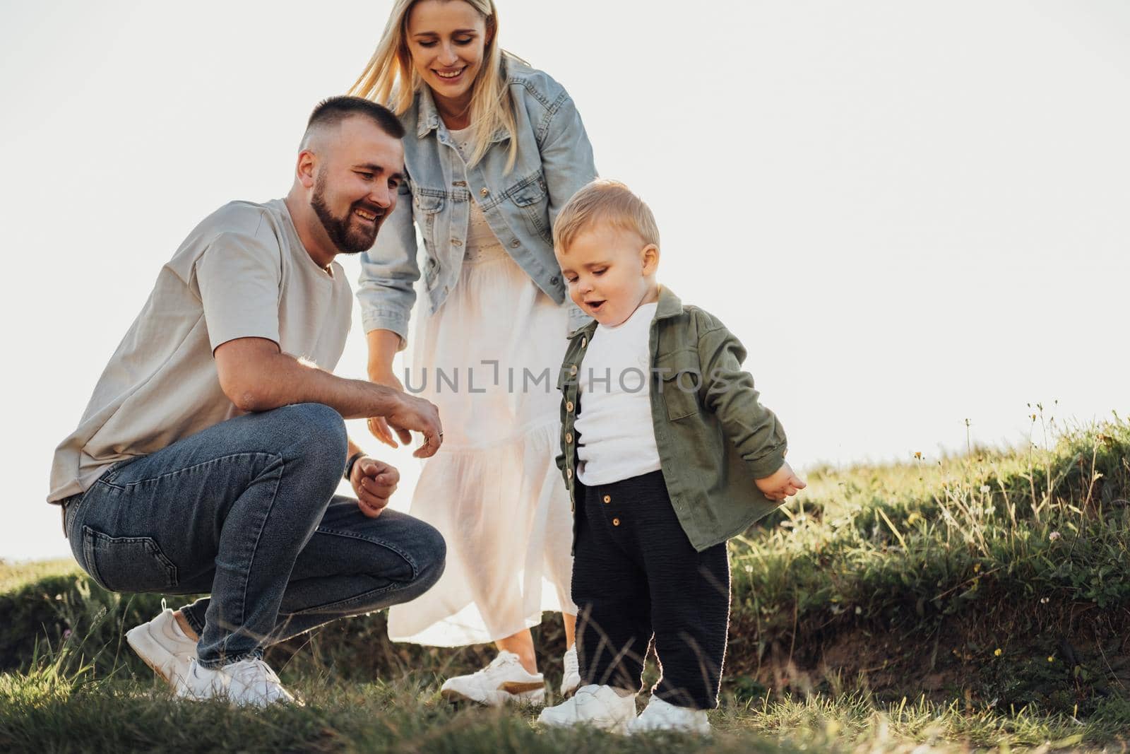 Portrait of Happy Young Family Outdoors, Father and Mother with Their Little Son Having Fun Time