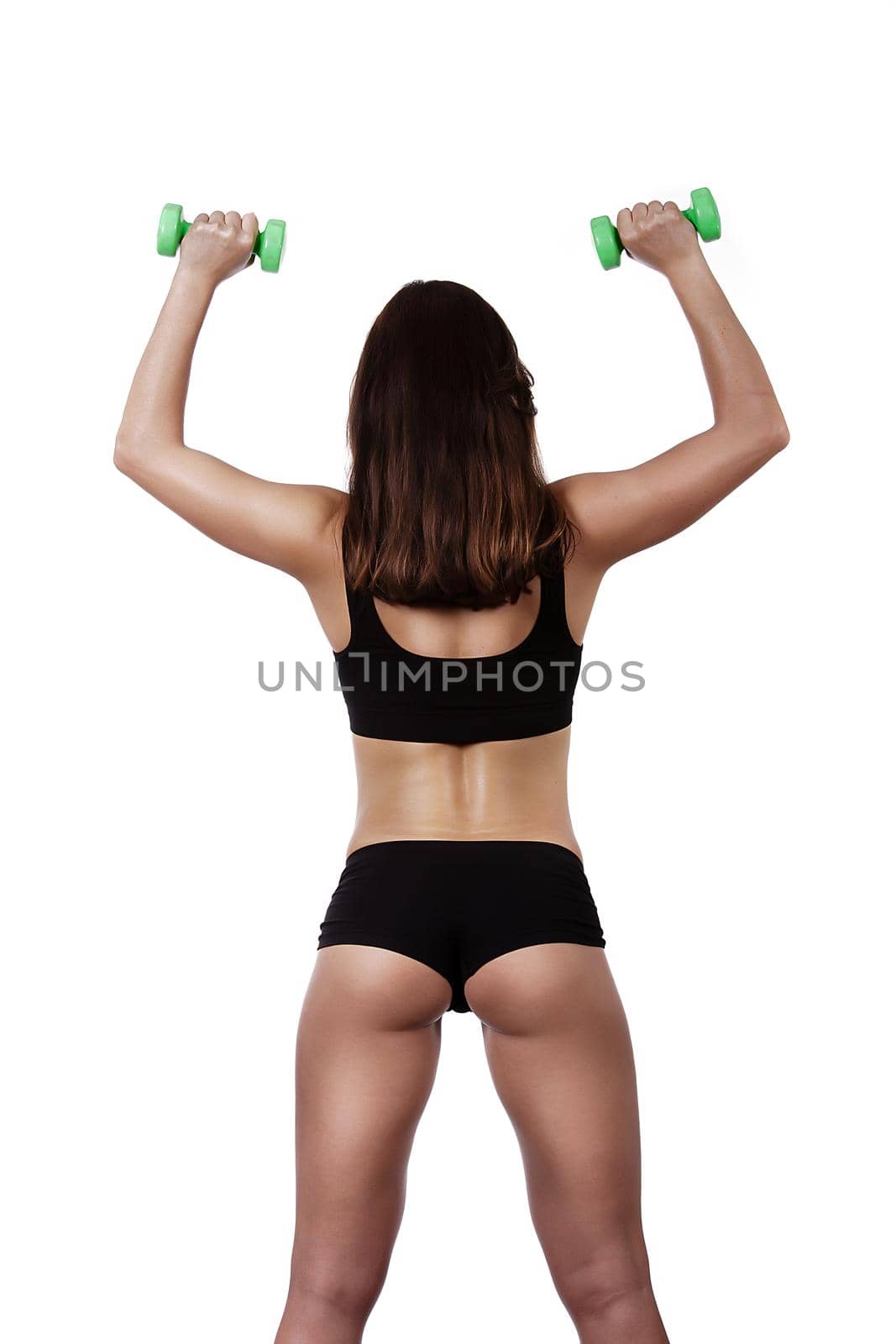 Fitness happy girl with dumbbells on a white background in black clothes behind