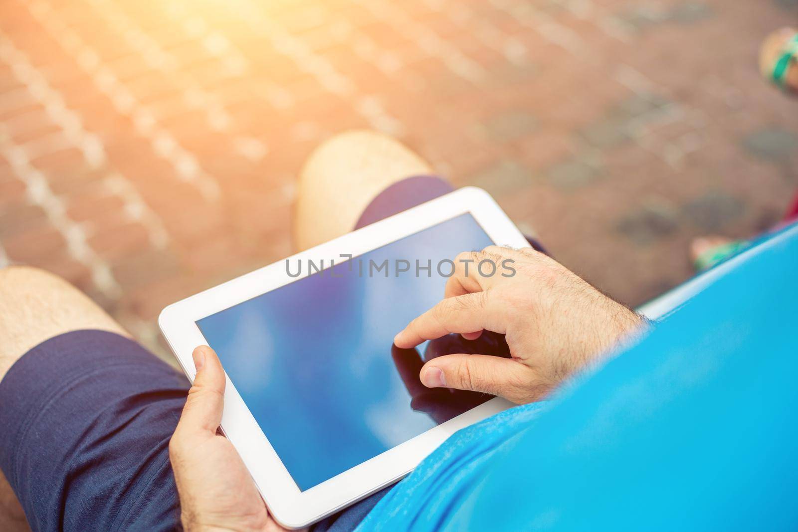 Man sitting on a bench and using a digital tablet by nazarovsergey