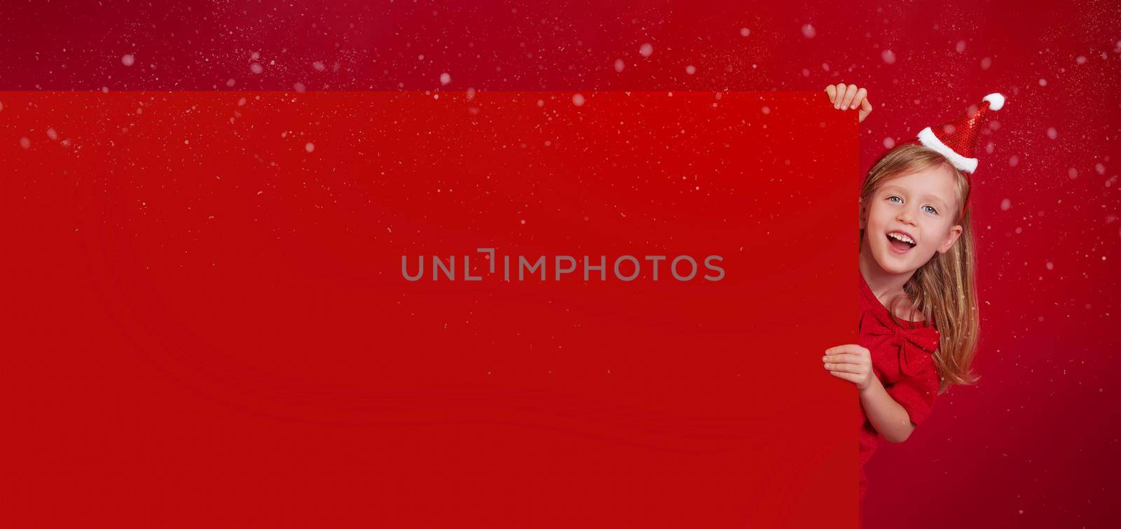 Merry Christmas poster copy paste. girl dressed as Santa Claus on a red background by Ramanouskaya