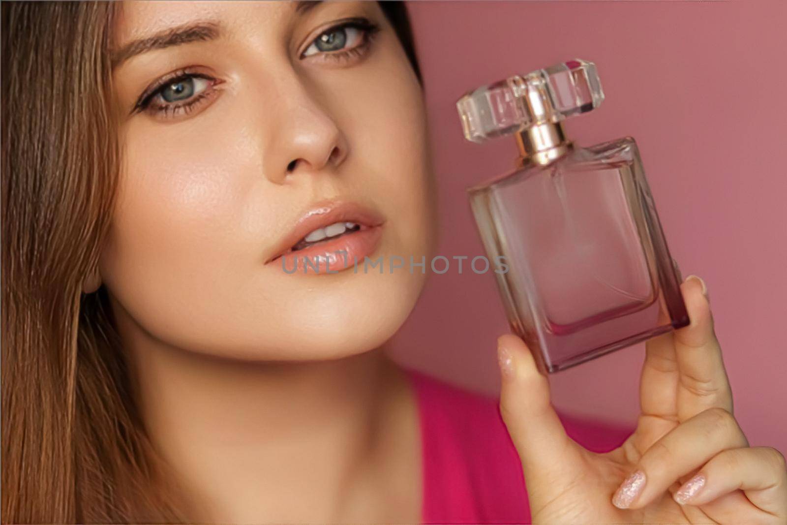 Perfume, beauty product and cosmetics model face portrait on pink background, beautiful woman holding fragrance bottle with floral feminine scent, fashion and makeup concept