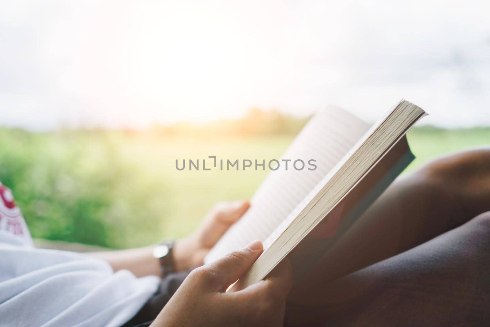 Woman is reading book in beautiful park and pond relax and peaceful environment by Suwant