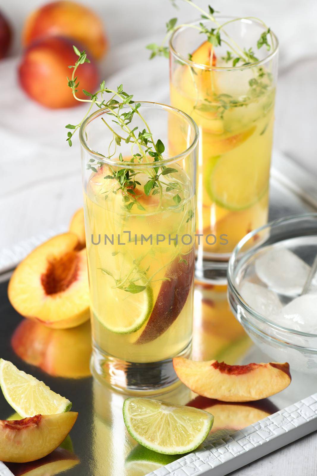Peach summer cocktail. Refreshing organic non-alcoholic drink, lemonade with ripe nectarine, thyme and lime  