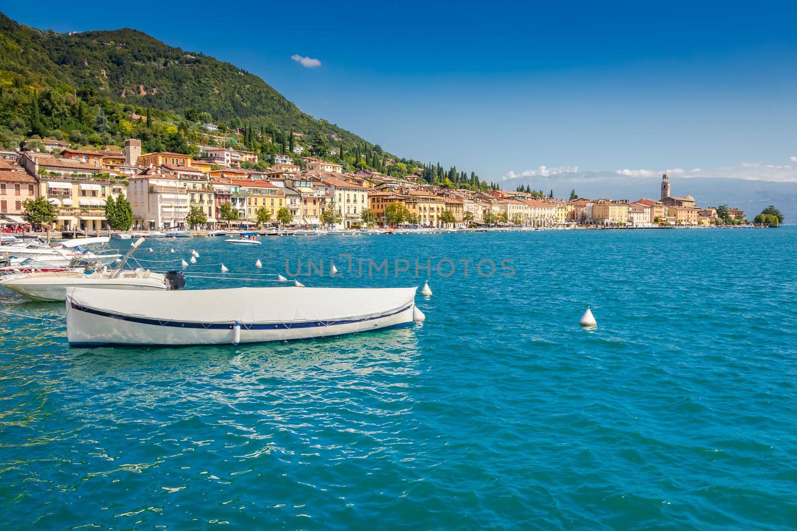 Idyllic lake Garda coastline and mediterranean village of Toscolano Maderno with sailboats and mountains, Northern Italy
