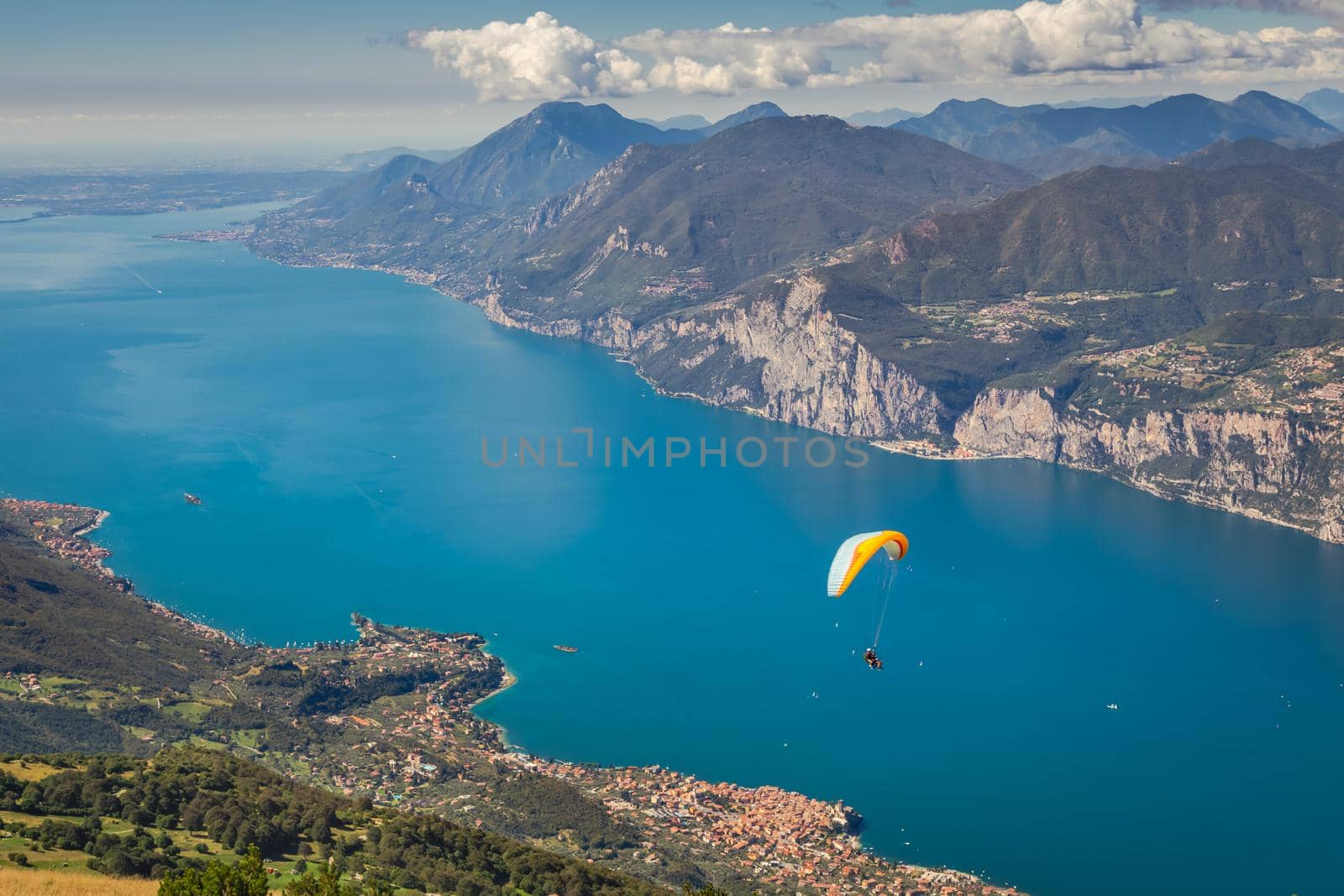 Paragliding above idyllic and turquoise Lake Garda from Monte Baldo, Malcesine, Northern Italy