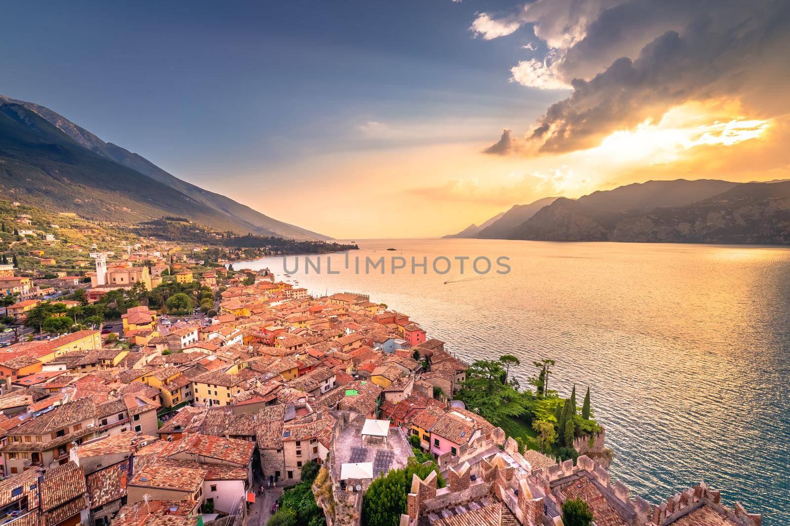 Above idyllic Lake Garda in Malcesine at dramatic sunset, northern Italian alps