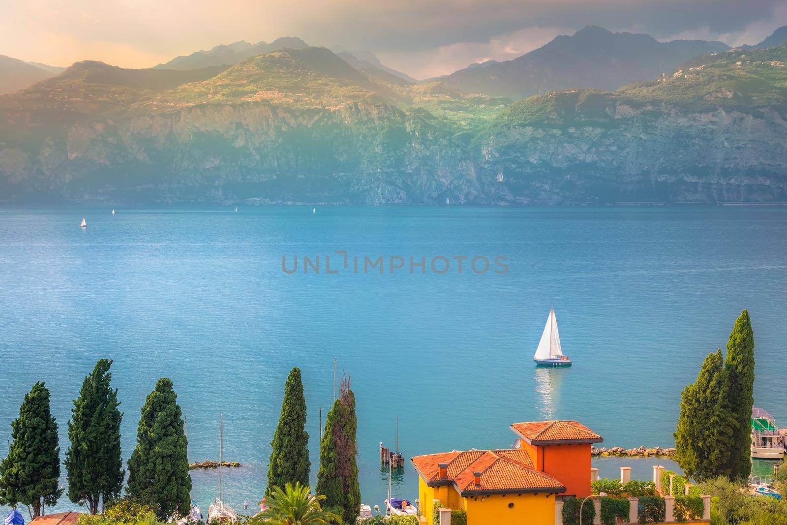Above idyllic Lake Garda in Malcesine at dramatic sunset, northern Italian alps