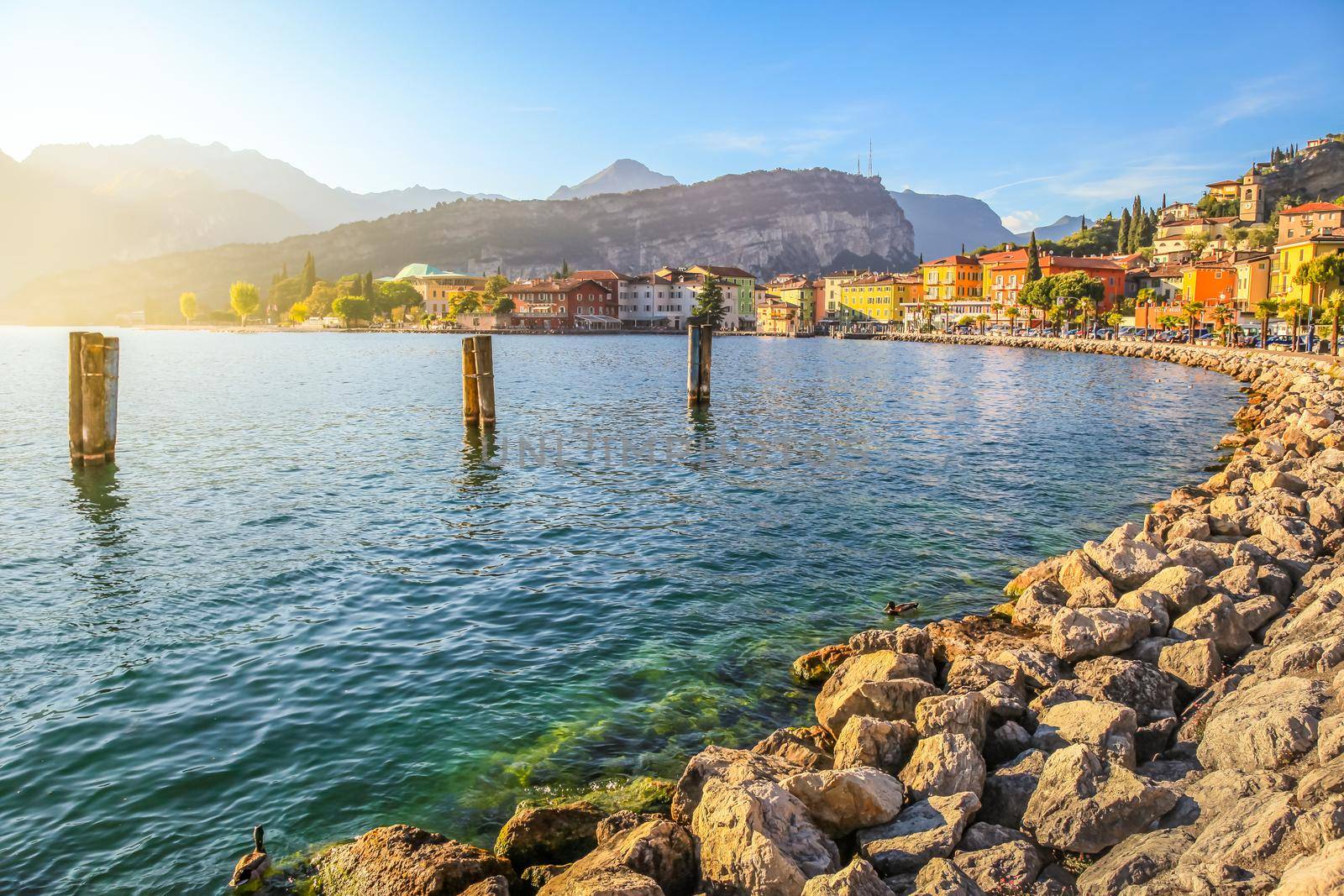 Idyllic Lake Garda coastline and Torbole village at sunset, Italian alps