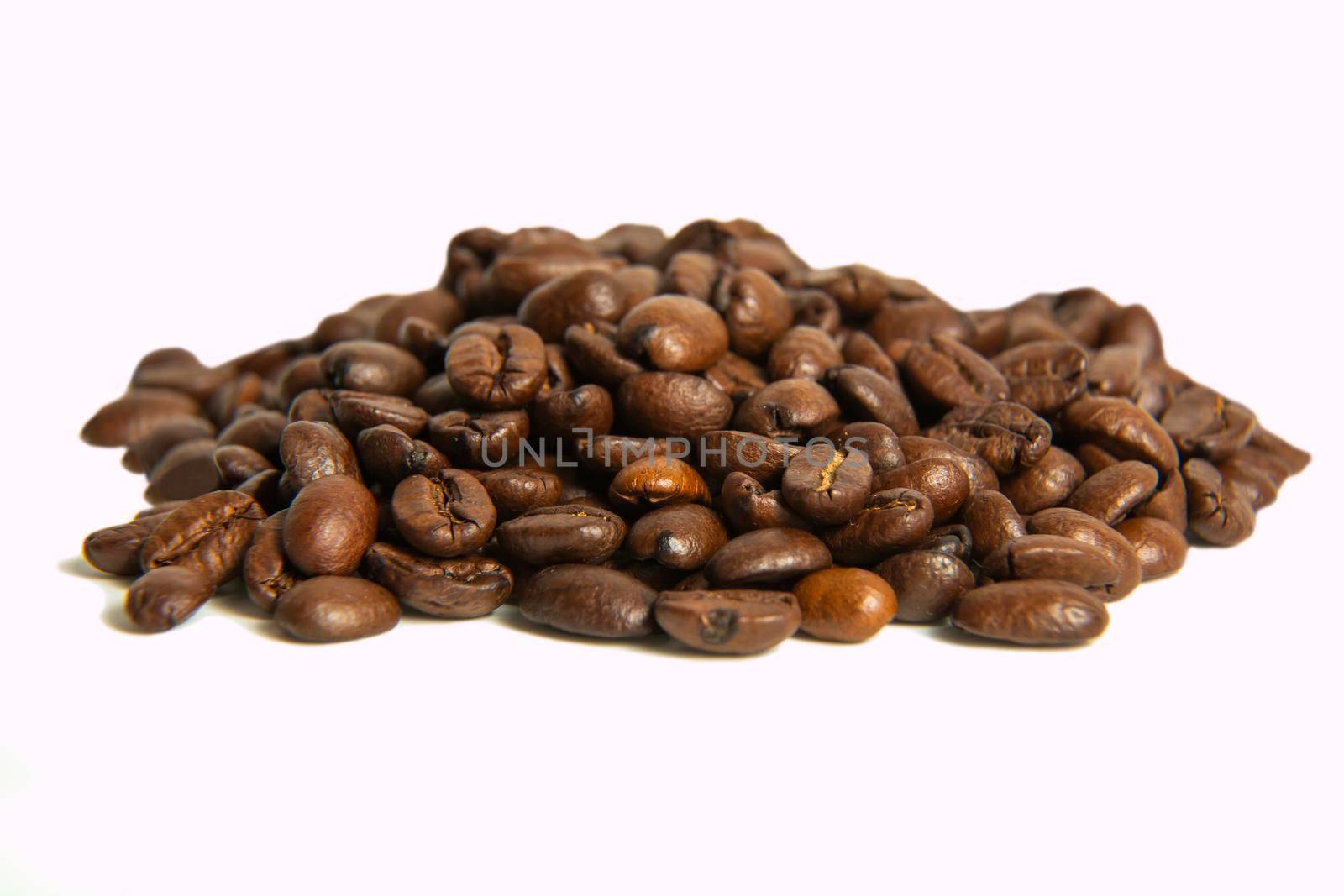 A bunch of coffee beans in close-up. roasted coffee beans on a light background. copy space