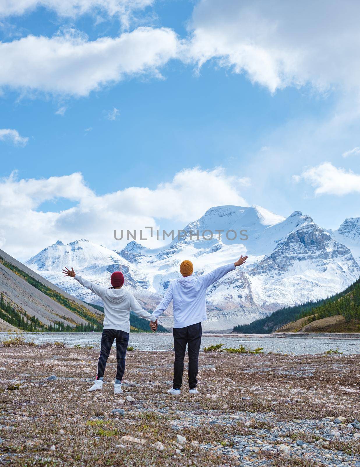 Icefields Parkway with autumn trees and snowy foggy mountains in Jasper Canada Alberta. couple of men and women on a road trip at Icefield parkway