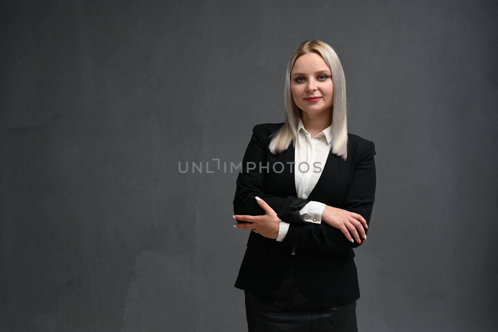 Portrait of successful business woman on a gray background.