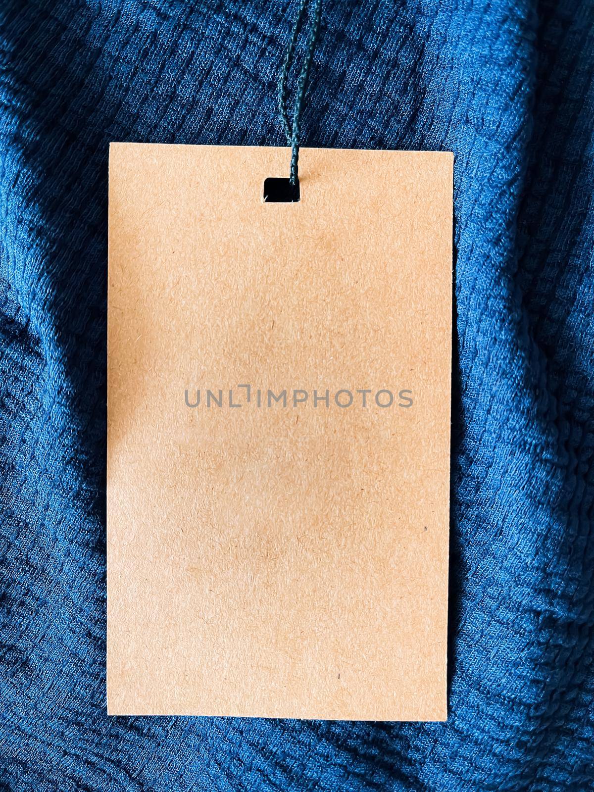 Blank fashion label tag, sale price card on luxury fabric background, shopping and retail concept