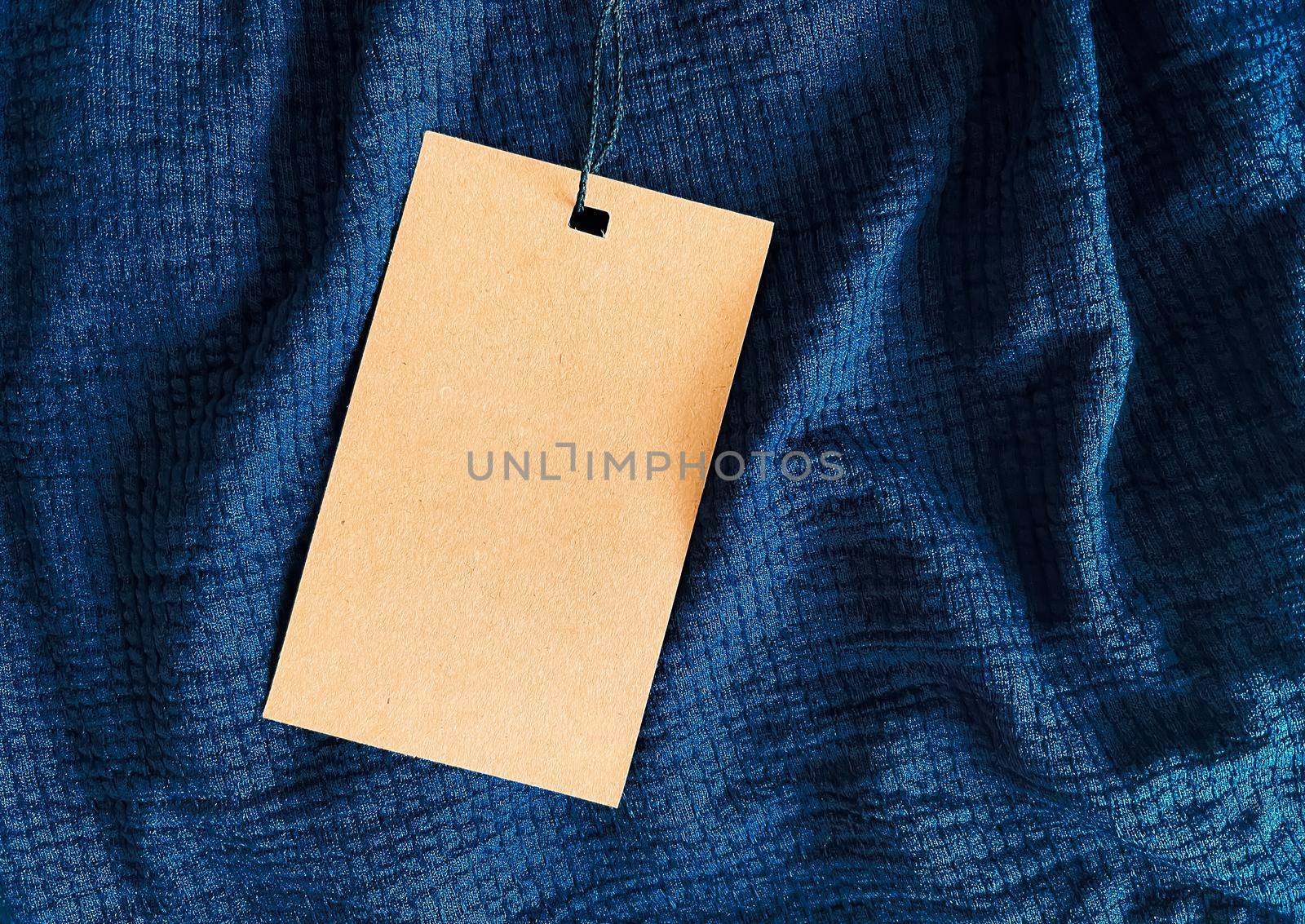 Blank fashion label tag, sale price card on luxury fabric background, shopping and retail concept