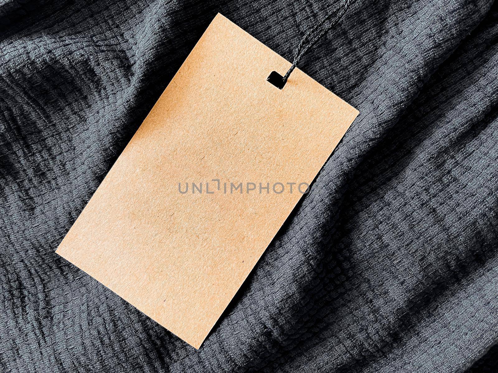 Blank fashion label tag, sale price card on luxury fabric background, shopping and retail concept